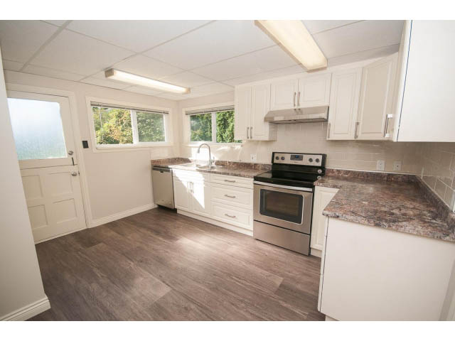 Bright kitchen with granite countertops, hardwood floors, and a city view. - 4135 Golf drive, North Vancouver
