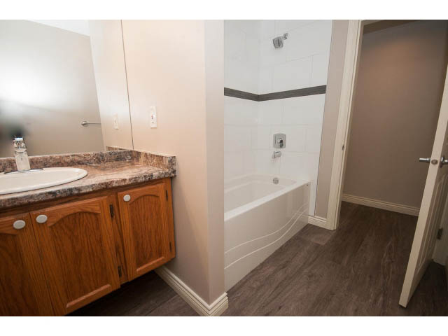 Bathroom with granite countertops, wooden cabinets, and a shower. - 4135 Golf drive, North Vancouver