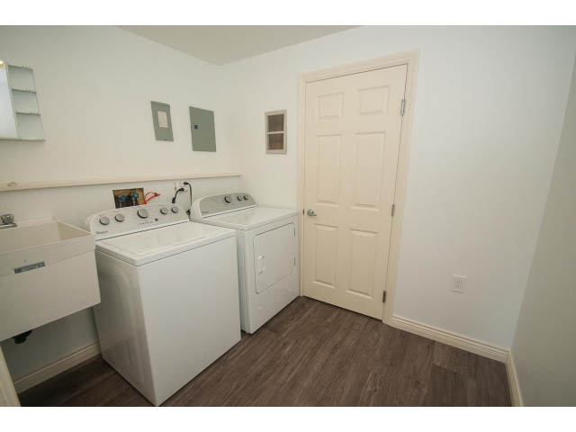 Bright laundry room with white appliances and hardwood floors. - 4135 Golf drive, North Vancouver