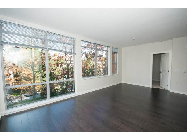 Spacious living room with hardwood floors and large windows, letting in natural light. - 414 - 255 West 1st St, North Vancouver