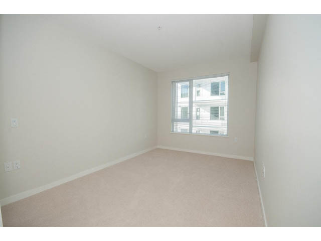 Bright living room with carpeted floor and large windows. - 414 - 255 West 1st St, North Vancouver