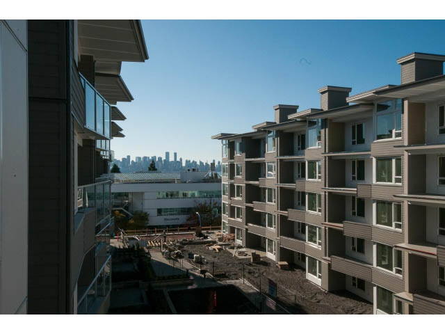 Bright living room with city view and modern furnishings. - 414 - 255 West 1st St, North Vancouver