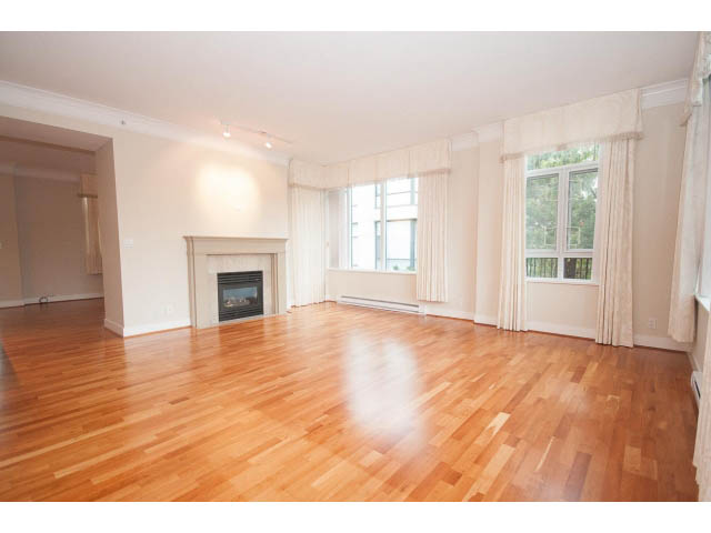 Bright living room with hardwood floors and large windows, showcasing a city view. - 708 - 4685 Valley Dr, Vancouver West Side