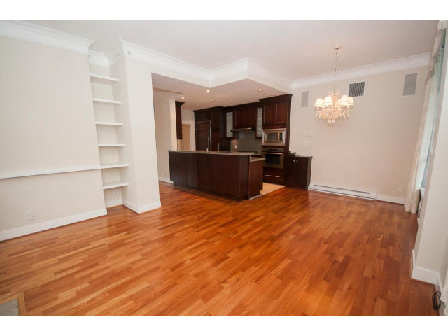 Bright kitchen with hardwood floors and built-in shelving, open to a cozy living area. - 708 - 4685 Valley Dr, Vancouver West Side