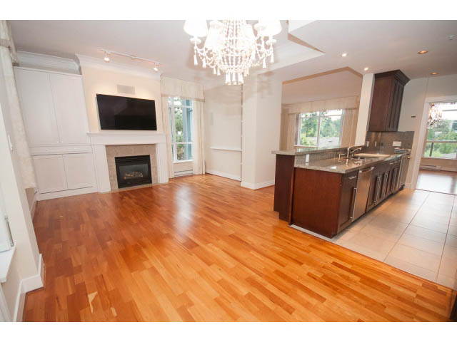 Bright kitchen with hardwood floors, stainless steel appliances, and city view. - 708 - 4685 Valley Dr, Vancouver West Side