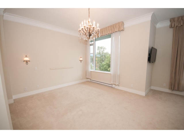 Spacious penthouse living room with a chandelier, wall-mounted TV, and large windows. - 708 - 4685 Valley Dr, Vancouver West Side