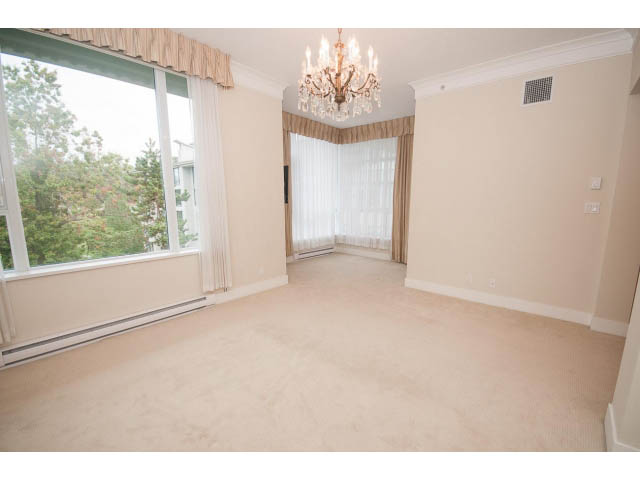 Bright living room with large windows, hardwood floors, and a chandelier. - 708 - 4685 Valley Dr, Vancouver West Side