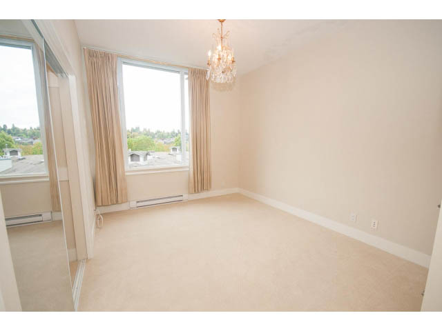 Bright living room with large windows, city view, and elegant chandelier. - 708 - 4685 Valley Dr, Vancouver West Side