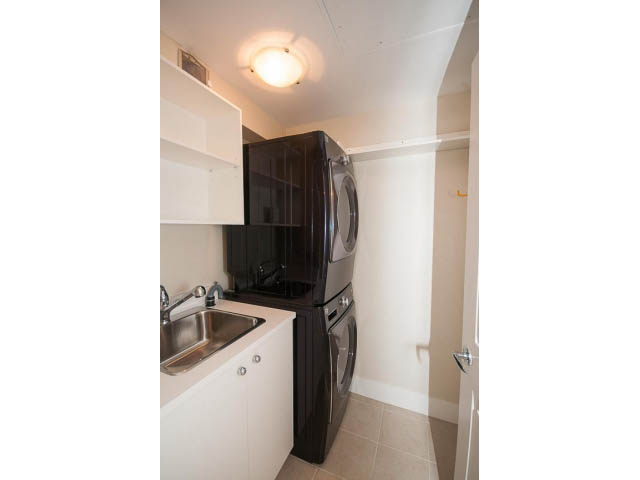 Bright kitchen with white cabinets, stainless steel sink, and black appliances. - 708 - 4685 Valley Dr, Vancouver West Side