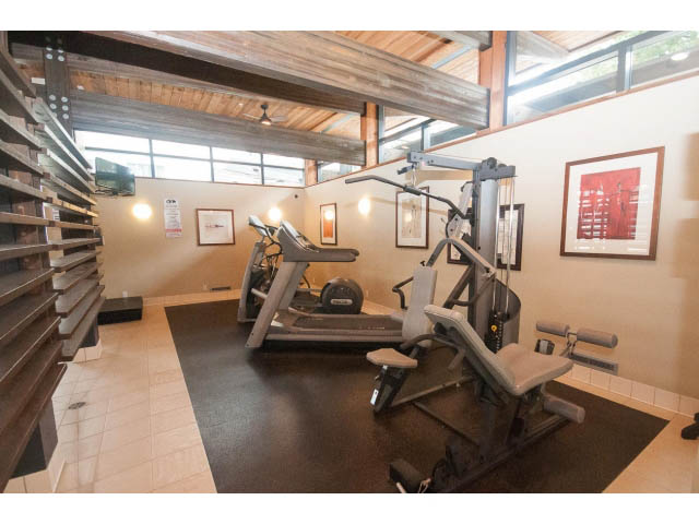 Bright and spacious fitness room with modern equipment and wooden beams. - 708 - 4685 Valley Dr, Vancouver West Side