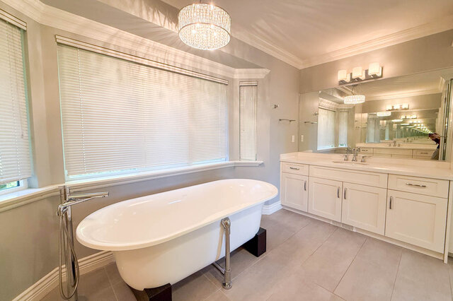 Ensuite clawfoot tub with a floor-mounted filler beside the double vanity. - 3858 Sauve Place, North Vancouver