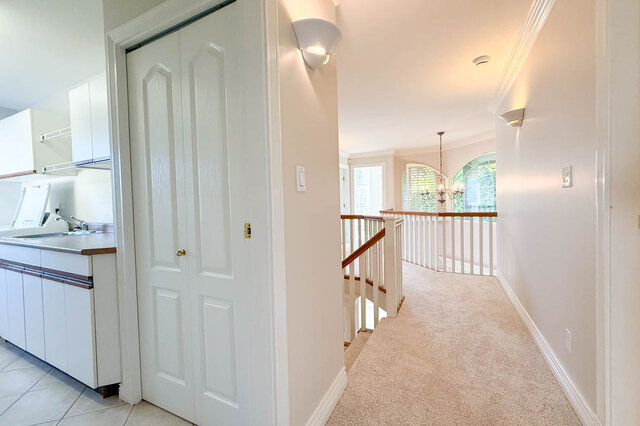 Upstairs hall past the laundry room to a landing with arched windows and a chandelier over the foyer. - 3858 Sauve Place, North Vancouver