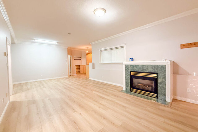 Lower-level flex room with the gas fireplace and hardwood floors running to built-in cabinets. - 3858 Sauve Place, North Vancouver