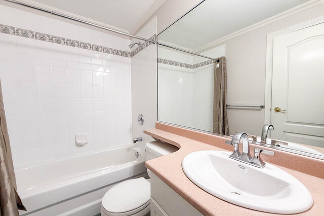 Lower-level bathroom with a tub and shower, a vanity and a large mirror. - 3858 Sauve Place, North Vancouver