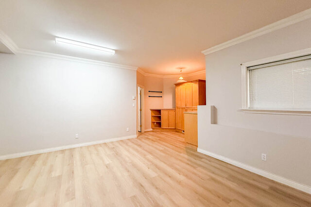 Open lower-level flex room with hardwood floors toward the built-in cabinets. - 3858 Sauve Place, North Vancouver
