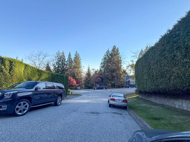 Quiet street with tall hedges and parked cars. - 3858 Sauve Place, North Vancouver