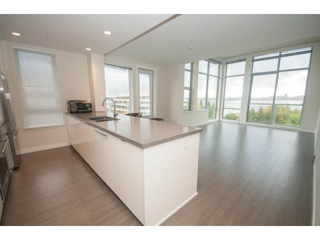 Bright kitchen with modern white cabinetry, hardwood floors, and a city view. - 524 - 255 West 1st St, North Vancouver