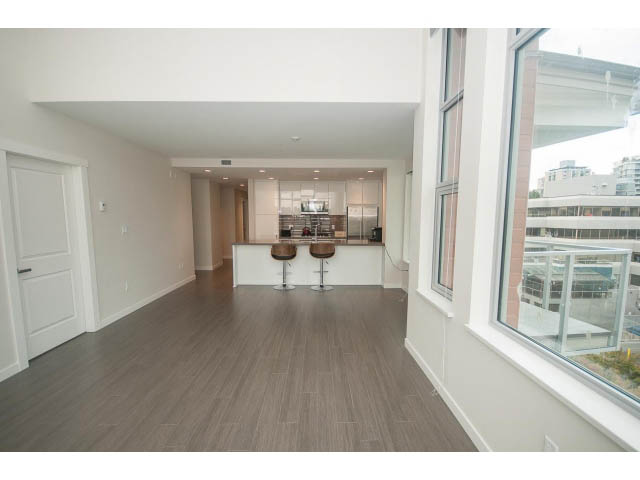 Bright open-concept penthouse with hardwood floors, modern kitchen, and city view. - 524 - 255 West 1st St, North Vancouver
