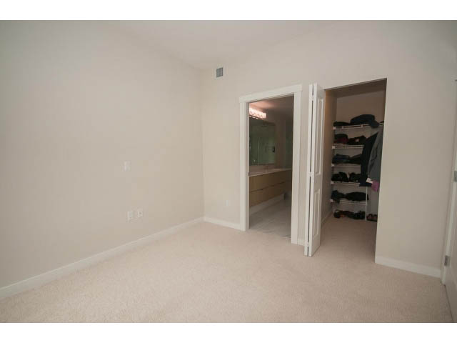 Bright bedroom with closet and built-in desk, neutral carpet. - 524 - 255 West 1st St, North Vancouver
