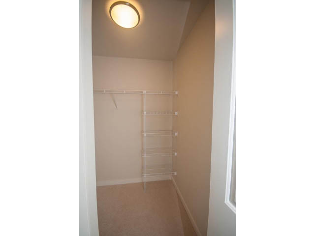 Bright walk-in closet with hanging rods and shelves. - 524 - 255 West 1st St, North Vancouver