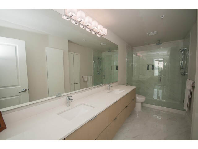 Spacious bathroom with white countertops and a large vanity mirror. - 524 - 255 West 1st St, North Vancouver