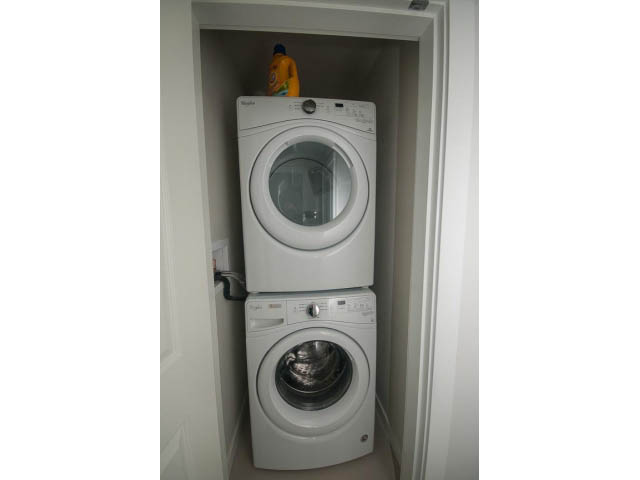 Bright laundry room with stacked washer and dryer, clean white interior. - 524 - 255 West 1st St, North Vancouver