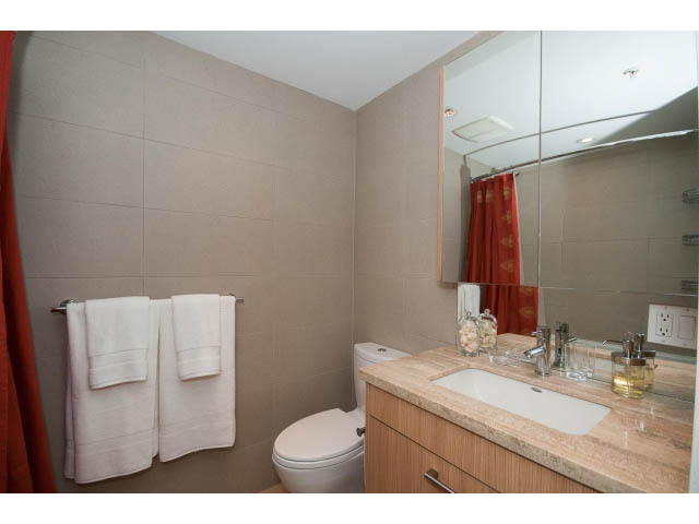 Furnished bathroom with beige walls, granite countertop, and wooden cabinets. - 802 - 1708 Columbia St, Vancouver West Side