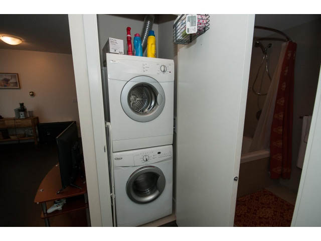 Bright laundry room with stacked washer and dryer, neatly organized. - 802 - 1708 Columbia St, Vancouver West Side