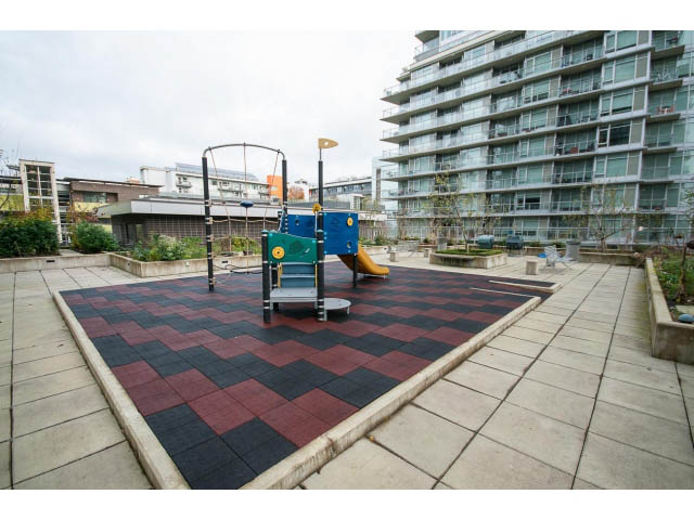 Furnished patio with colorful rubber matting and modern apartment building in background. - 802 - 1708 Columbia St, Vancouver West Side