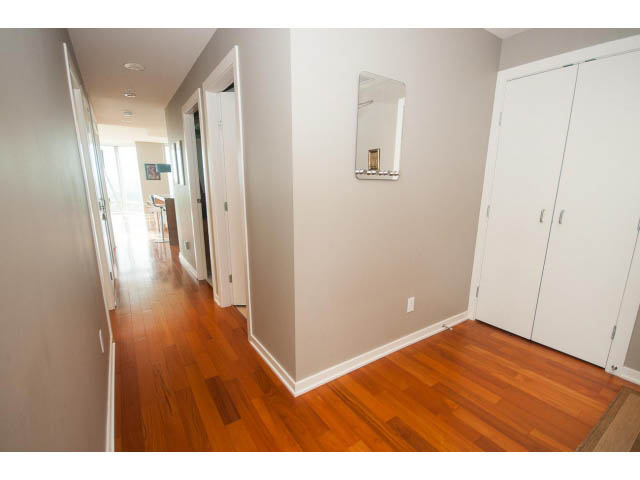 Bright hallway with hardwood floors and white closet doors, leading to a room with a city view. - 2401 - 1005 Beach Avenue, Vancouver Downtown