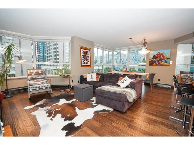 Spacious living room with hardwood floors, cowhide rug, and city view. - 303 - 717 Jervis St, Vancouver Downtown