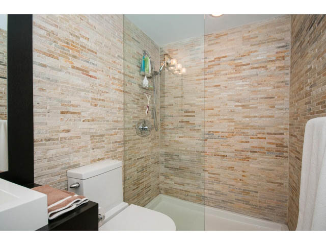Furnished bathroom with stone-look tiles and a walk-in shower. - 303 - 717 Jervis St, Vancouver Downtown