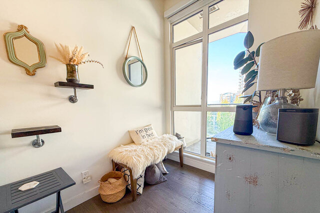 Cozy den with hardwood floors, a fur-draped bench, and a large window framing a bright exterior view. - 503-105 West 2nd Street, North Vancouver