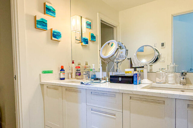 Bathroom vanity with white marble countertops, shaker cabinets, and dual round makeup mirrors. - 503-105 West 2nd Street, North Vancouver