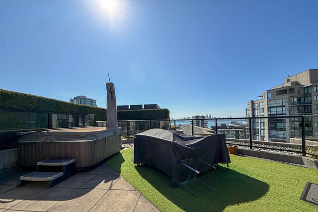 Rooftop terrace with a covered hot tub, artificial turf, and a distant water and city view. - 503-105 West 2nd Street, North Vancouver