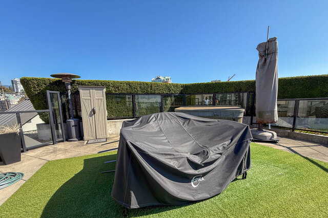 Private rooftop patio with artificial turf, a covered grill, and a glass railing overlooking the city. - 503-105 West 2nd Street, North Vancouver