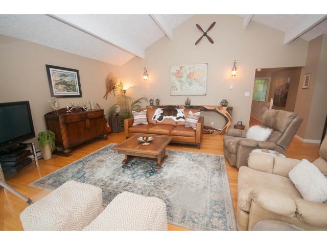 Spacious living room with hardwood floors, plush furniture, and a world map on the wall. - 8135 Pasco Rd, West Vancouver