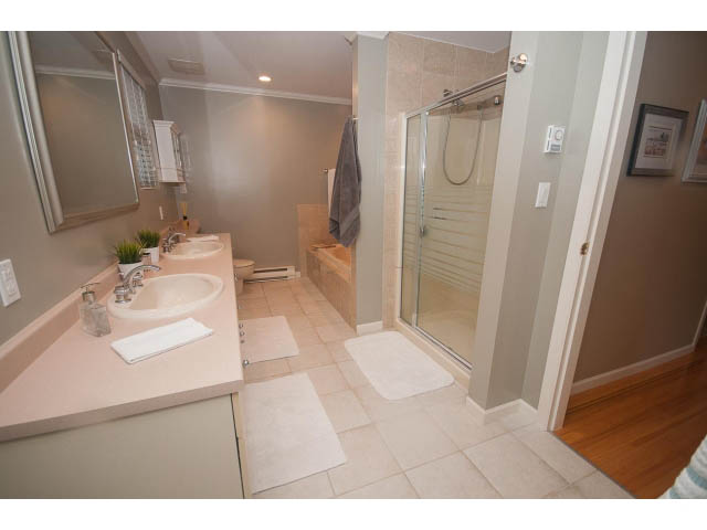 Bright bathroom with pink countertops and hardwood floors. - 8135 Pasco Rd, West Vancouver