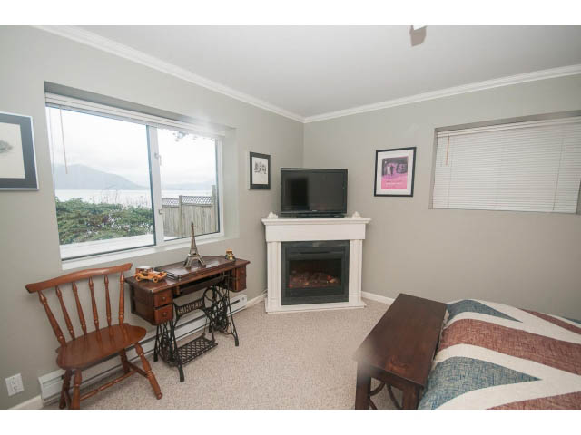 Living room with a city view, cozy furniture, and a fireplace. - 8135 Pasco Rd, West Vancouver