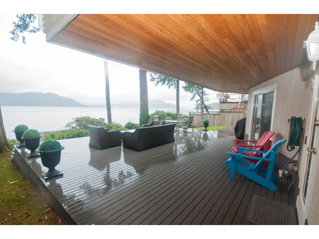 Furnished deck with wooden flooring, overlooking a serene lake view. - 8135 Pasco Rd, West Vancouver