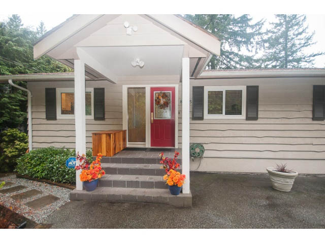 Furnished 4-bedroom house with a welcoming front porch and colorful flower pots. - 8135 Pasco Rd, West Vancouver