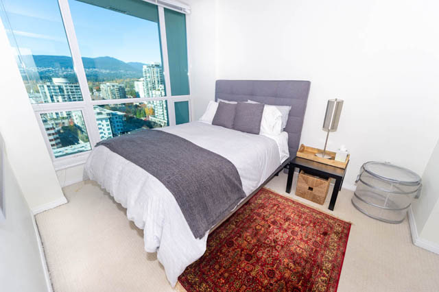 Spacious bedroom with a city view and modern furnishings. - 1905 - 138 East Esplanade Ave, North Vancouver