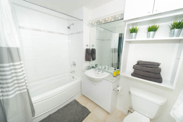 Furnished bathroom with white tiles, modern fixtures, and a large mirror. - 1905 - 138 East Esplanade Ave, North Vancouver