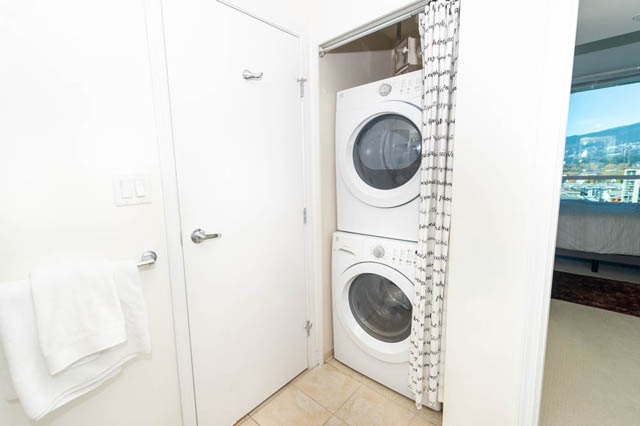 Bright laundry room with white appliances and city view. - 1905 - 138 East Esplanade Ave, North Vancouver