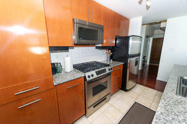 Bright kitchen with granite countertops, stainless steel appliances, and hardwood floors. - 1905 - 138 East Esplanade Ave, North Vancouver