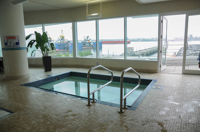 Spacious living room with large windows, city view, and modern furnishings. - 1905 - 138 East Esplanade Ave, North Vancouver