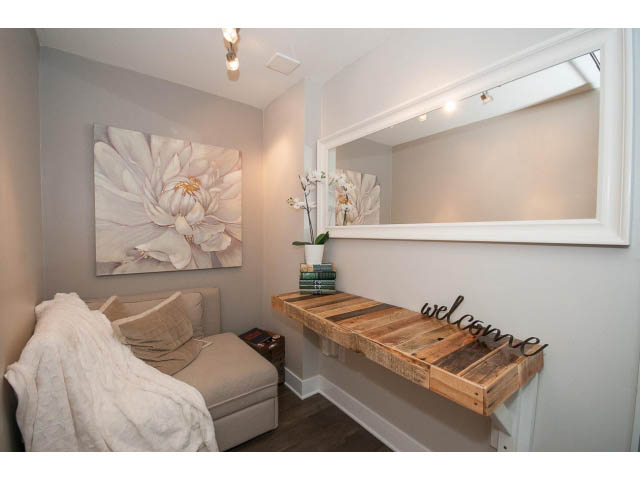 Furnished den with floral artwork, wooden bench, and cozy seating. - 106 - 1868 W. 5th Avenue, Vancouver West Side