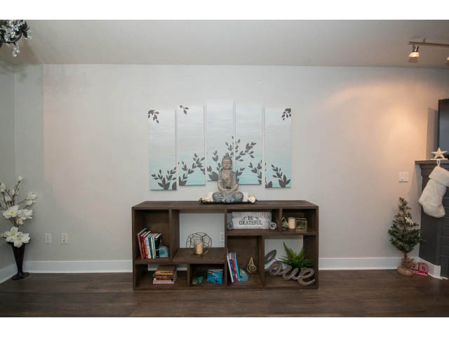 Bright living room with wooden shelves, artwork, and cozy decor. - 106 - 1868 W. 5th Avenue, Vancouver West Side