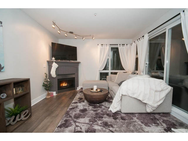 Furnished living room with hardwood floors, cozy rug, and large window with curtains. - 106 - 1868 W. 5th Avenue, Vancouver West Side