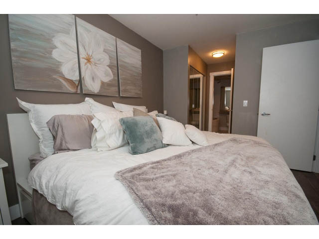 Furnished 1-bedroom + den with cozy bedding, large artwork, and neutral decor. - 106 - 1868 W. 5th Avenue, Vancouver West Side